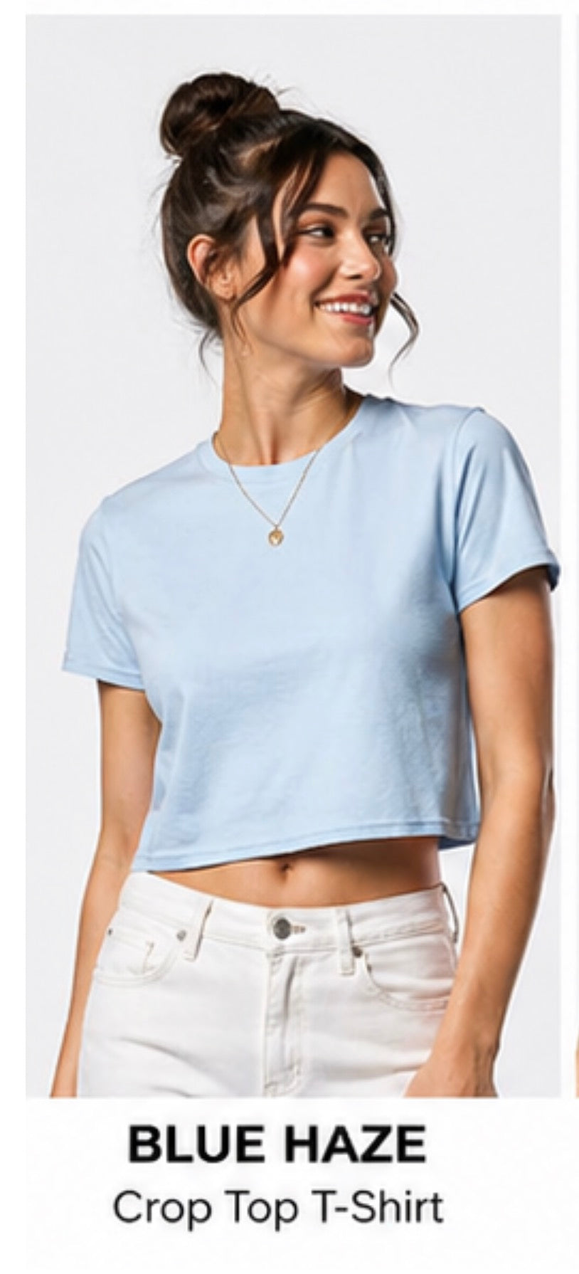 Woman wearing a light blue crop top t-shirt with text 'Blue Haze Crop Top T-Shirt' below.